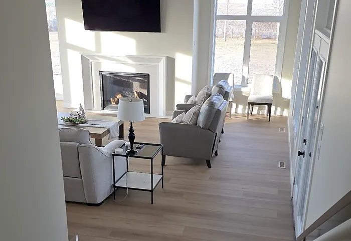 Living room with a fireplace and new plank flooring, seen from the top of the stairs