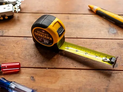 Measuring tape and tools on a wood surface