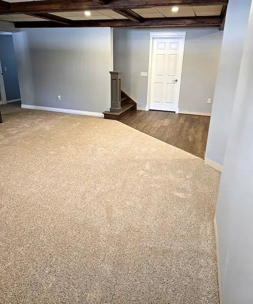 Carpeted basement with a beamed ceiling