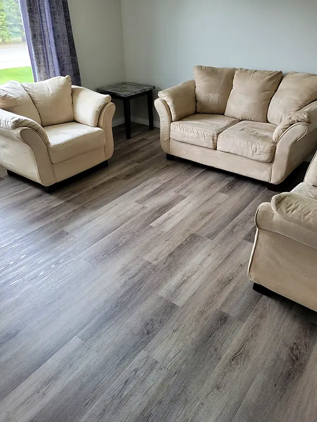 Living room with light gray plank flooring and cream furniture