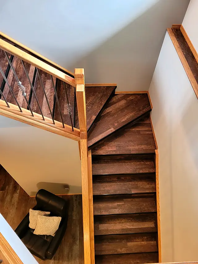 Staircase and landing finished in dark brown plank flooring