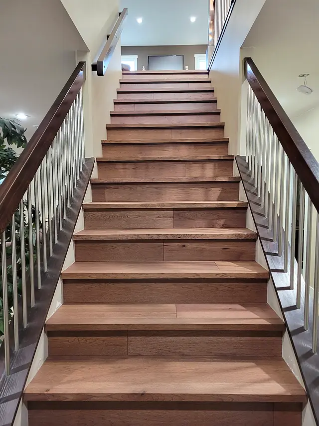 Wide staircase with solid wood treads and white balusters