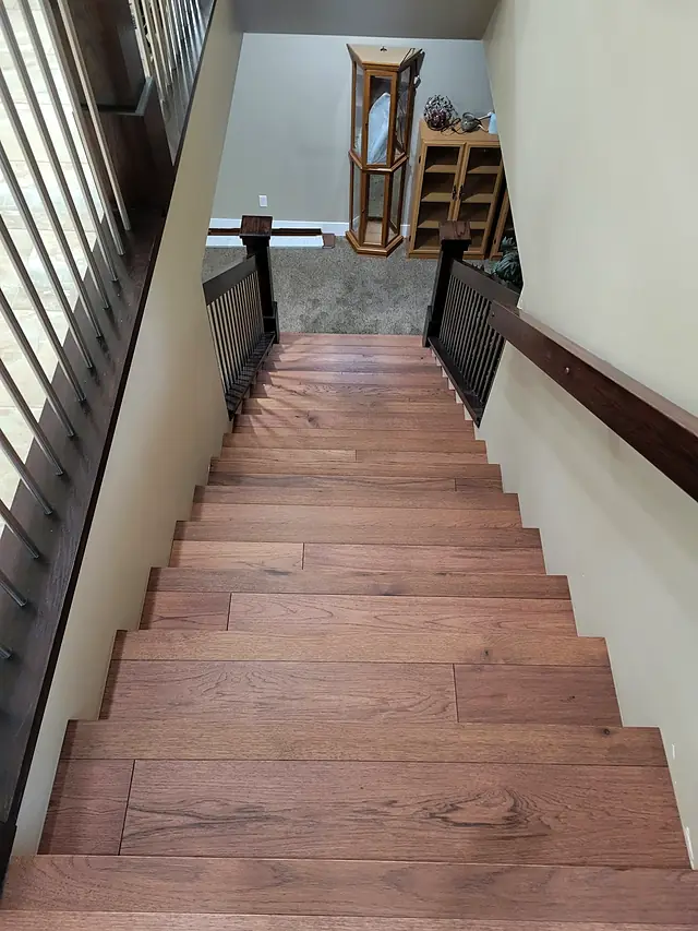 Wood staircase leading down to a carpeted lower level