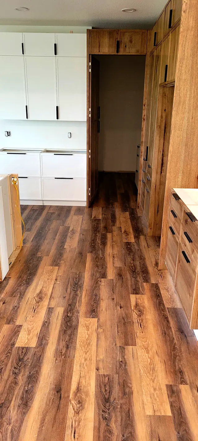 Kitchen with white cabinets and warm brown plank flooring