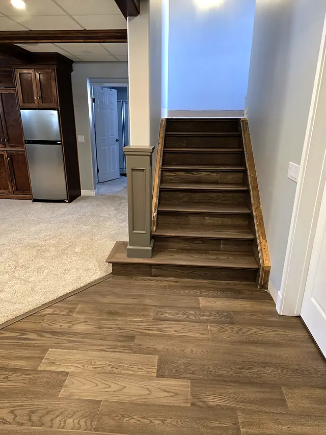 Basement staircase with wood flooring and carpet